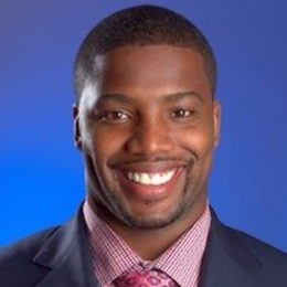 Kevin Bentley wearing a suit and tie smiling at the camera